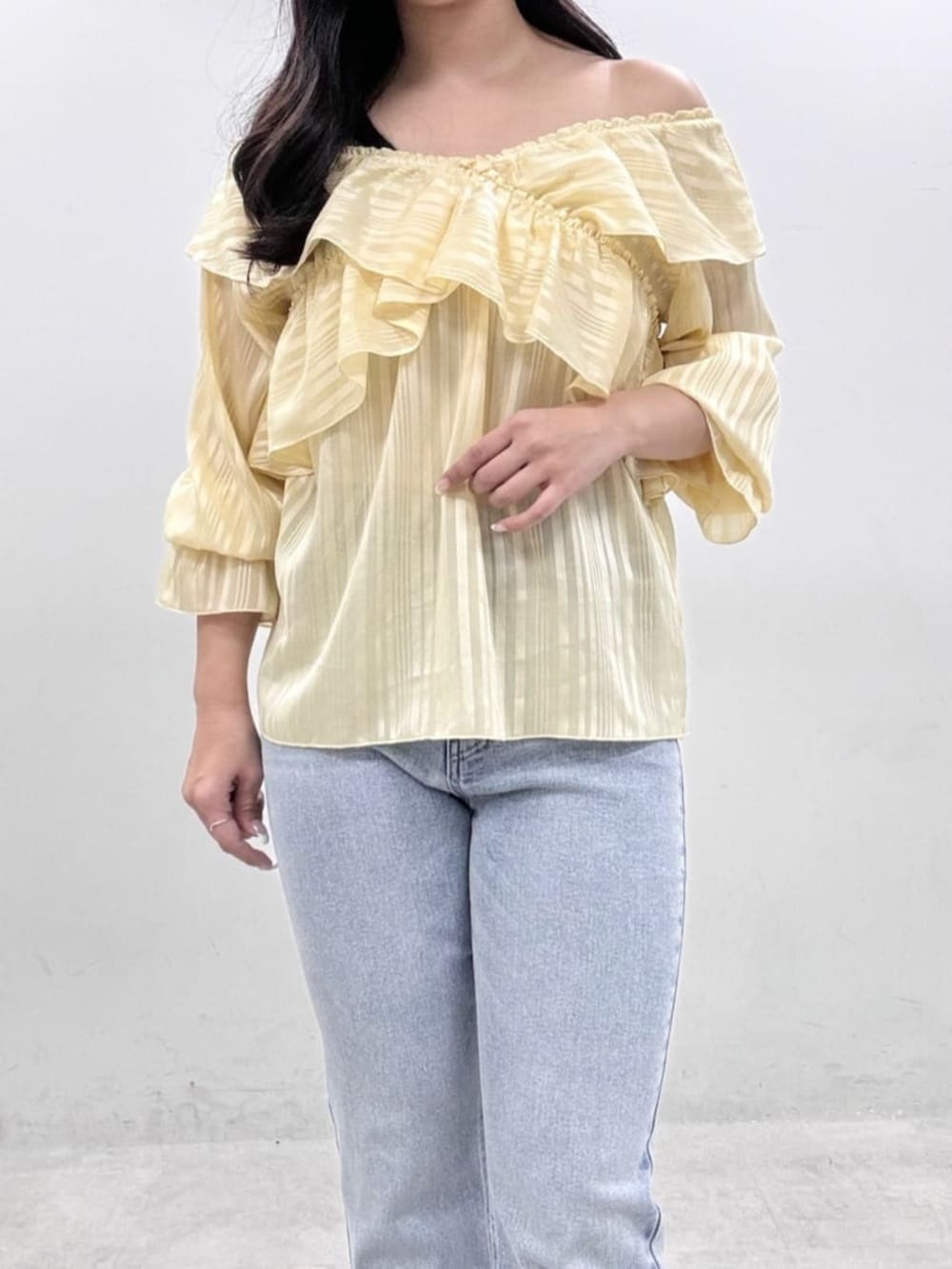 イエロー系のシャツ/ブラウス、ブルー系のデニムパンツを着用したレディースの冬コーディネートの7枚目の写真