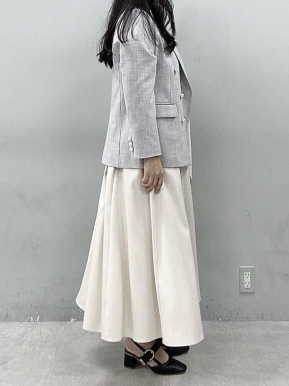 グレー系のテーラードジャケット、ホワイト系のワンピース、ブルー系のTシャツ/カットソーを着用したレディースの春コーディネートの2枚目の写真