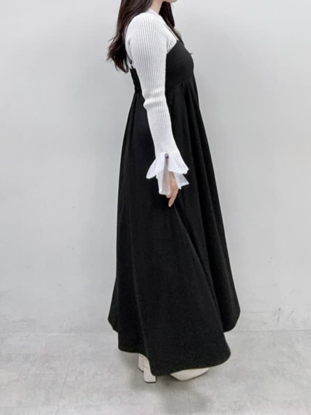 グレー系のニット/セーター、ブラック系のワンピースを着用したレディースの冬コーディネートの2枚目の写真