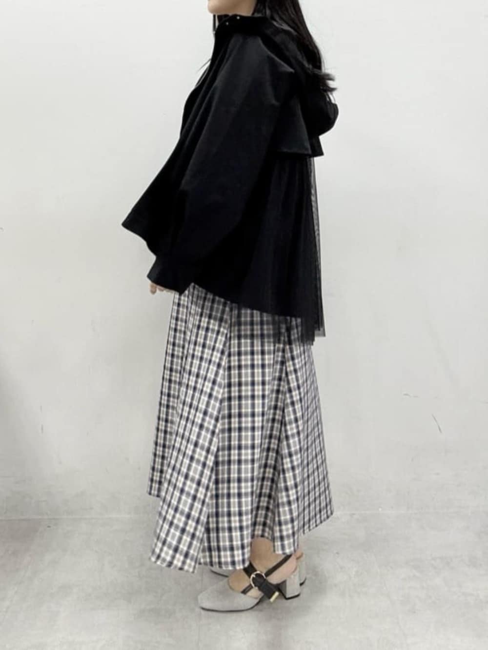 グレー系のサンダル、ブルー系のワンピース、ブラック系のマウンテンパーカーを着用したレディースの冬コーディネートの2枚目の写真