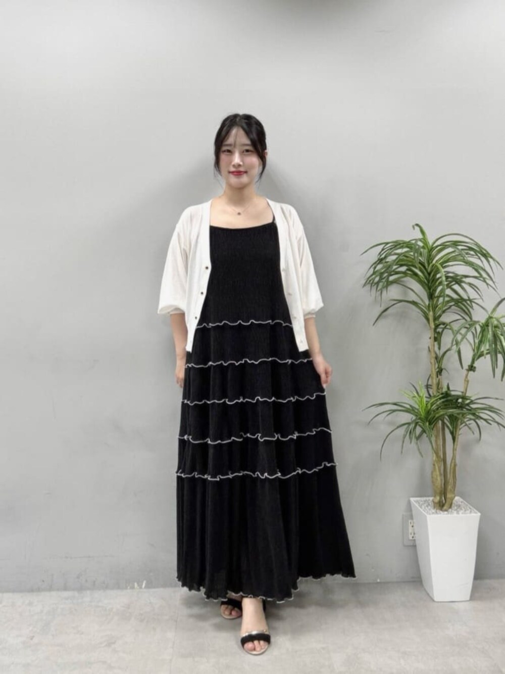 ホワイト系のカーディガン/ボレロ、ブラック系のワンピースを着用したレディースの夏コーディネートの2枚目の写真