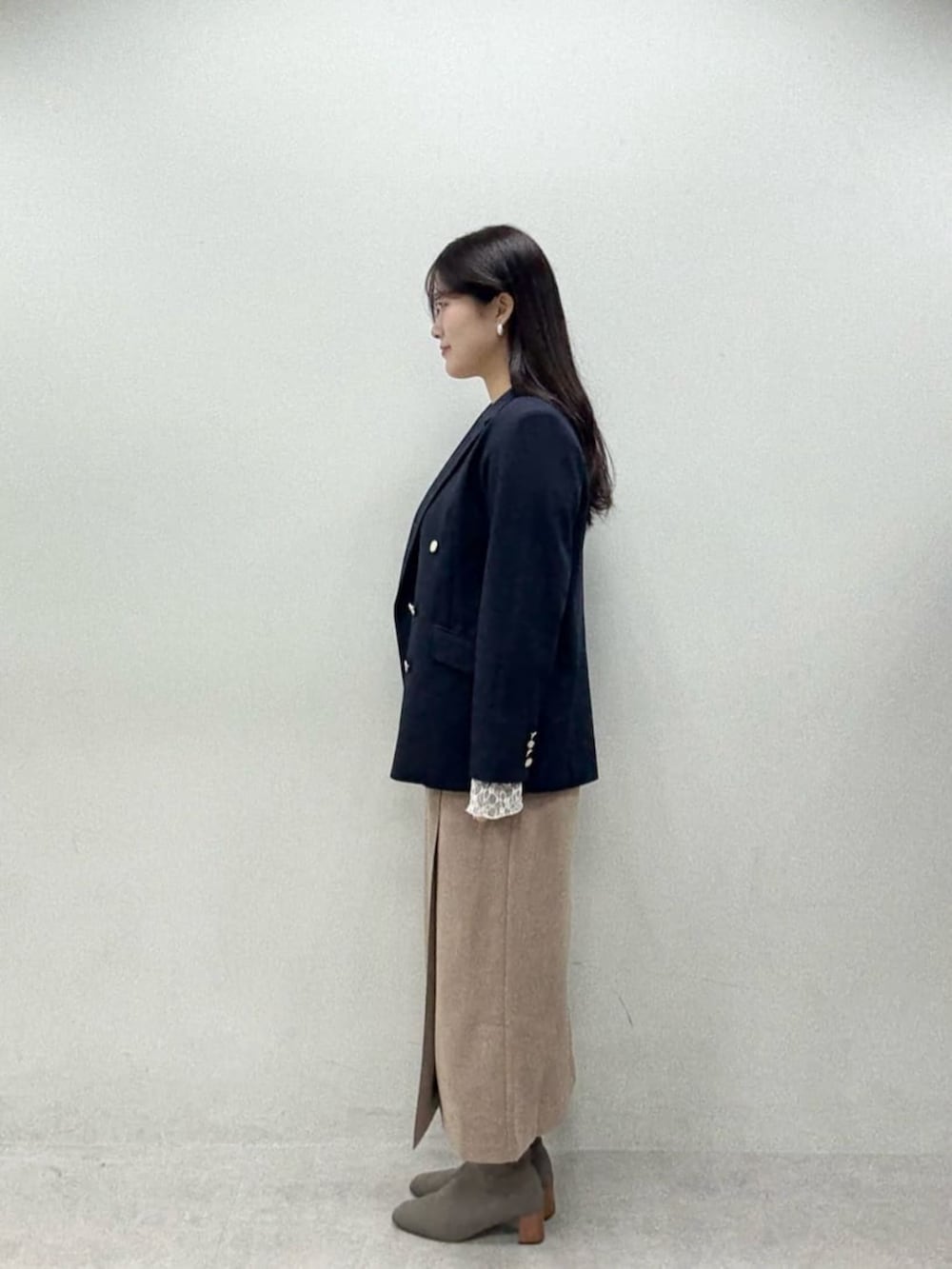 ブラウン系のスカート、ブルー系のテーラードジャケット、グレー系のTシャツ/カットソーを着用したレディースの秋コーディネートの2枚目の写真