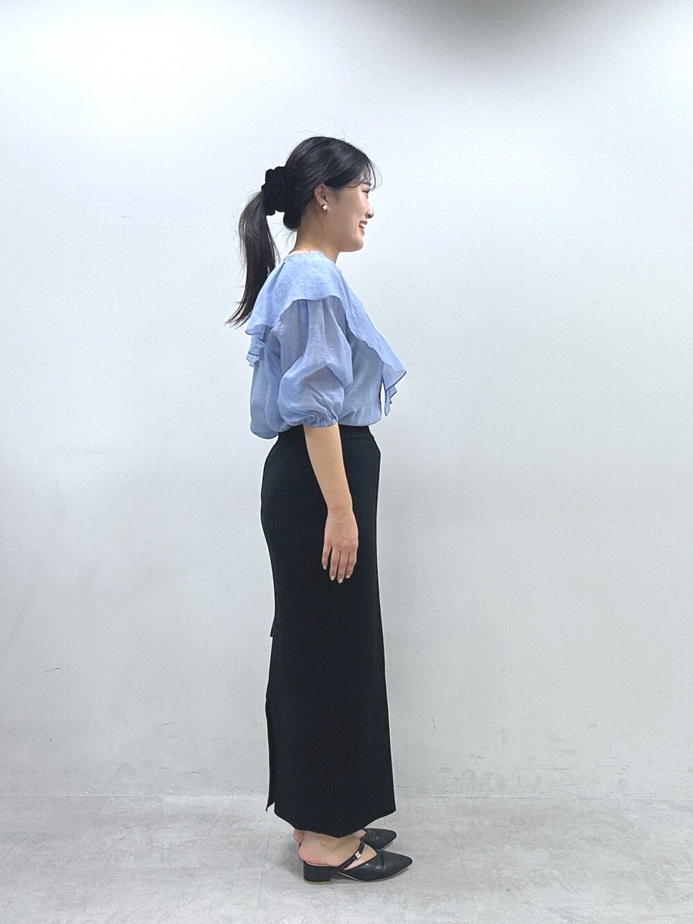 ブラック系のスカート、ブルー系のシャツ/ブラウスを着用したレディースの春コーディネートの2枚目の写真