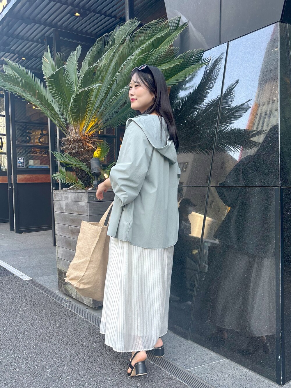 ベージュ系のワンピース、ブラック系のサンダルを着用したレディースの春コーディネートの2枚目の写真