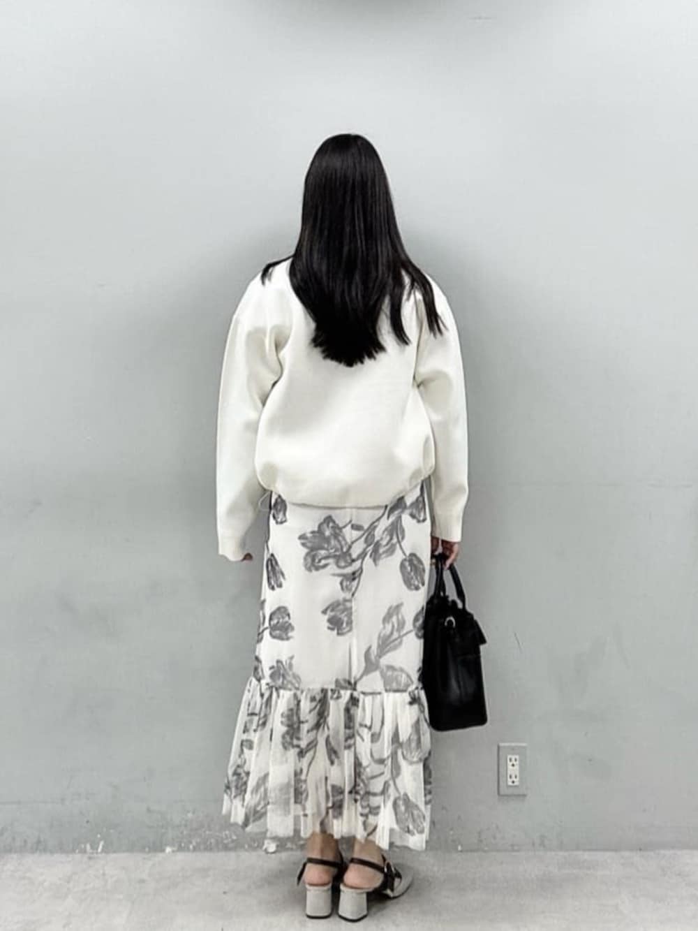 ブラック系のショルダーバッグ、ホワイト系のブルゾン、グレー系のニット/セーターを着用したレディースの春コーディネートの3枚目の写真