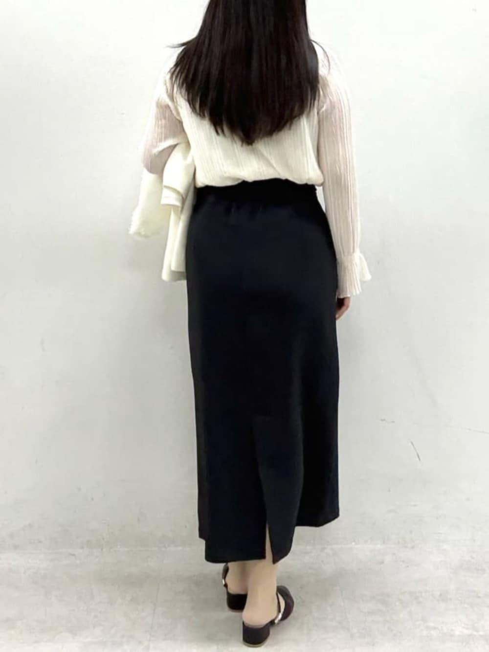 ブラック系のスカート、ホワイト系のノーカラージャケット、ホワイト系のシャツ/ブラウスを着用したレディースの冬コーディネートの6枚目の写真