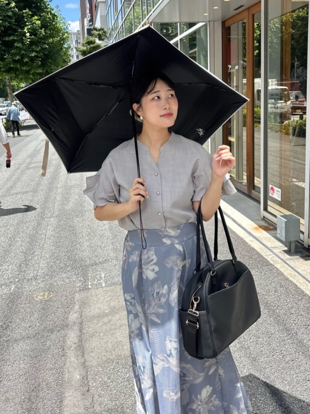 グレー系のシャツ/ブラウス、ブラック系のボストンバッグ、ブルー系のスカートを着用したレディースの夏コーディネートの5枚目の写真