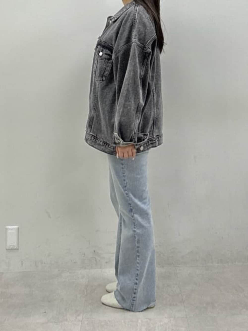 ブルー系のデニムパンツ、ホワイト系のサンダル、イエロー系のニット/セーターを着用したレディースの冬コーディネートの2枚目の写真