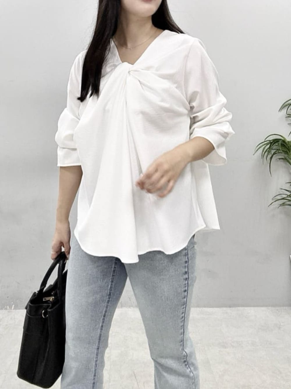 ブルー系のデニムパンツ、ブラック系のショルダーバッグ、ホワイト系のシャツ/ブラウスを着用したレディースの春コーディネートの4枚目の写真