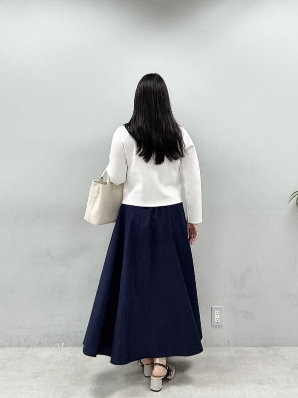 ホワイト系のショルダーバッグ、ホワイト系のノーカラージャケットを着用したレディースの春コーディネートの3枚目の写真