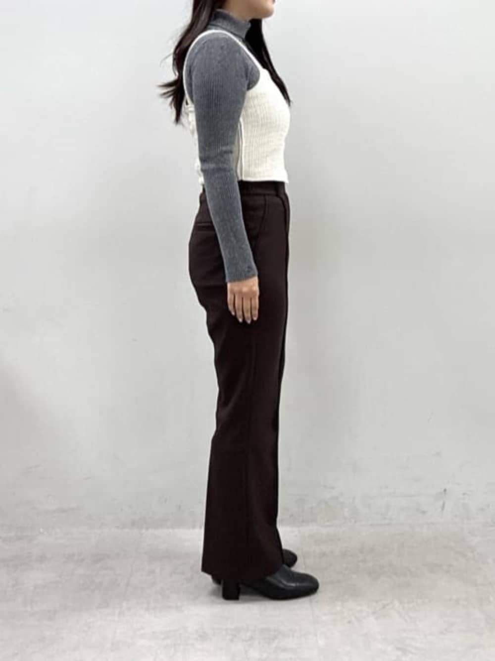 ホワイト系のシャツ/ブラウス、ブラウン系のスラックス、グレー系のニット/セーターを着用したレディースの秋コーディネートの2枚目の写真