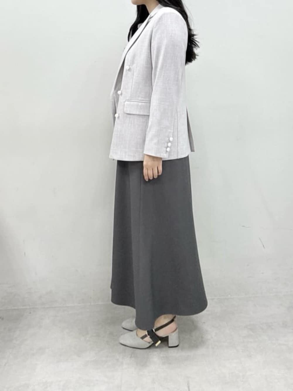 ホワイト系のテーラードジャケット、ホワイト系のハンドバッグ、グレー系のサンダルを着用したレディースの春コーディネートの5枚目の写真