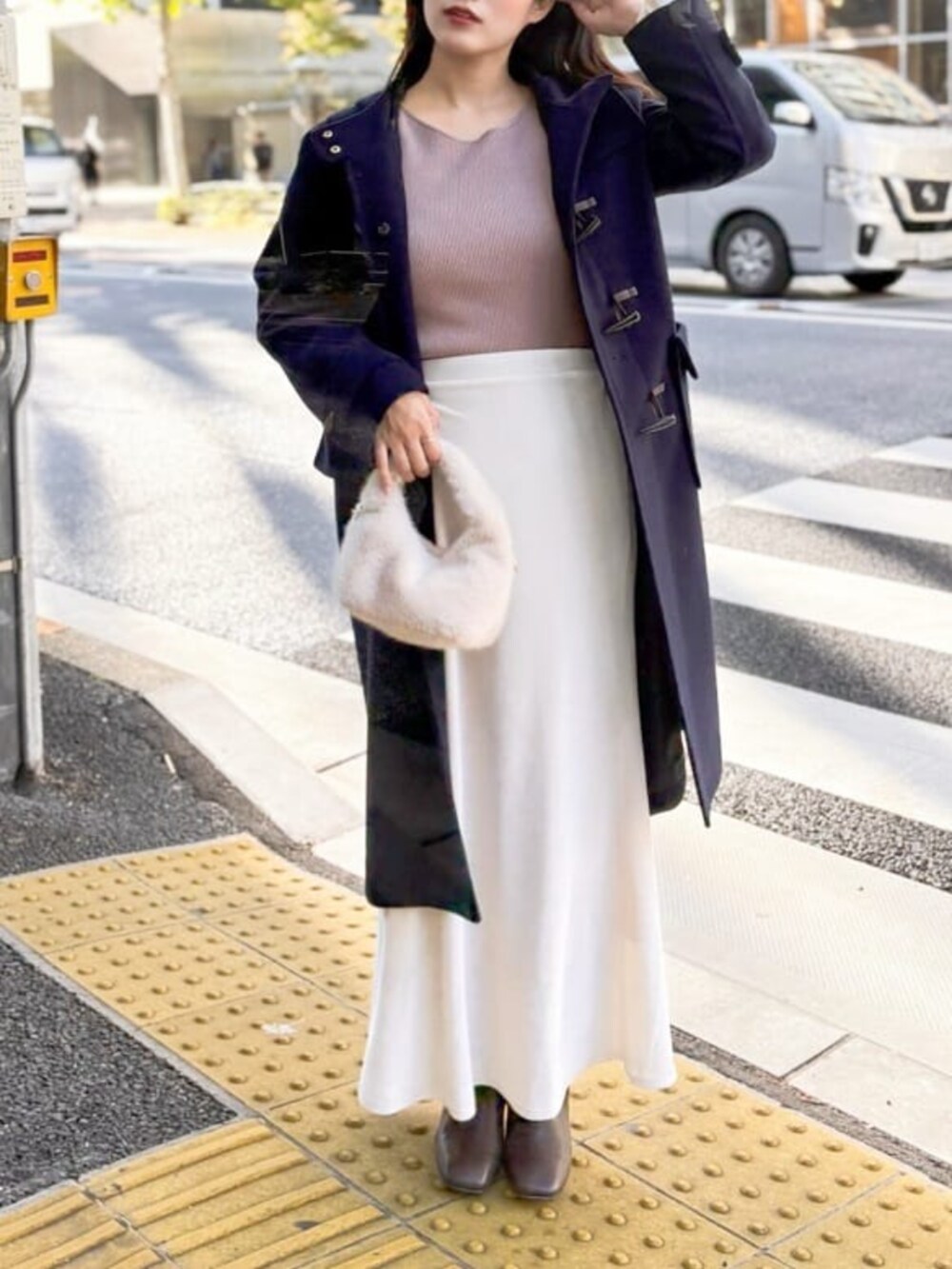 ホワイト系のスカート、ベージュ系のニット/セーターを着用したレディースの冬コーディネートの3枚目の写真