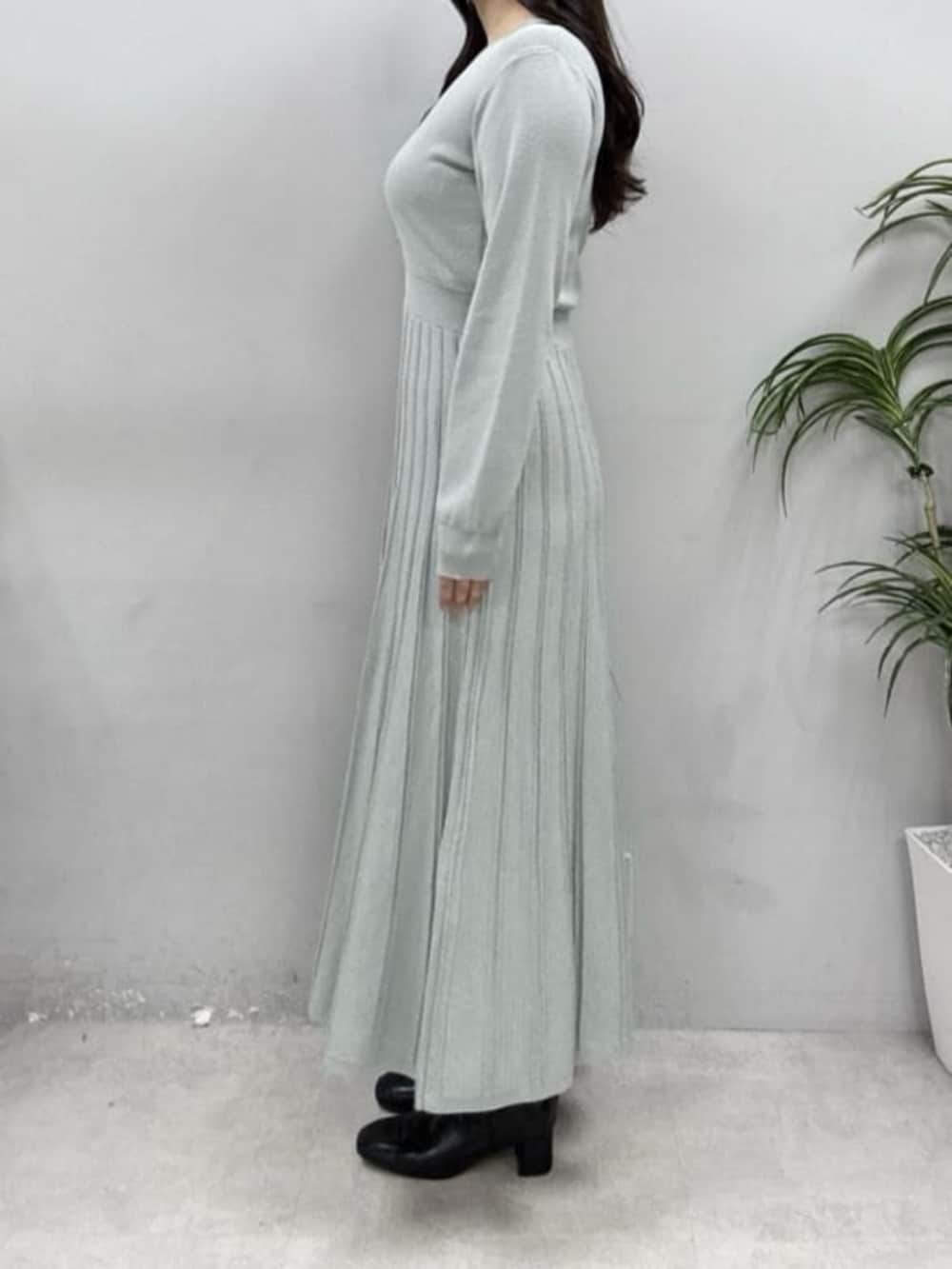 グリーン系のワンピースを着用したレディースの冬コーディネートの2枚目の写真