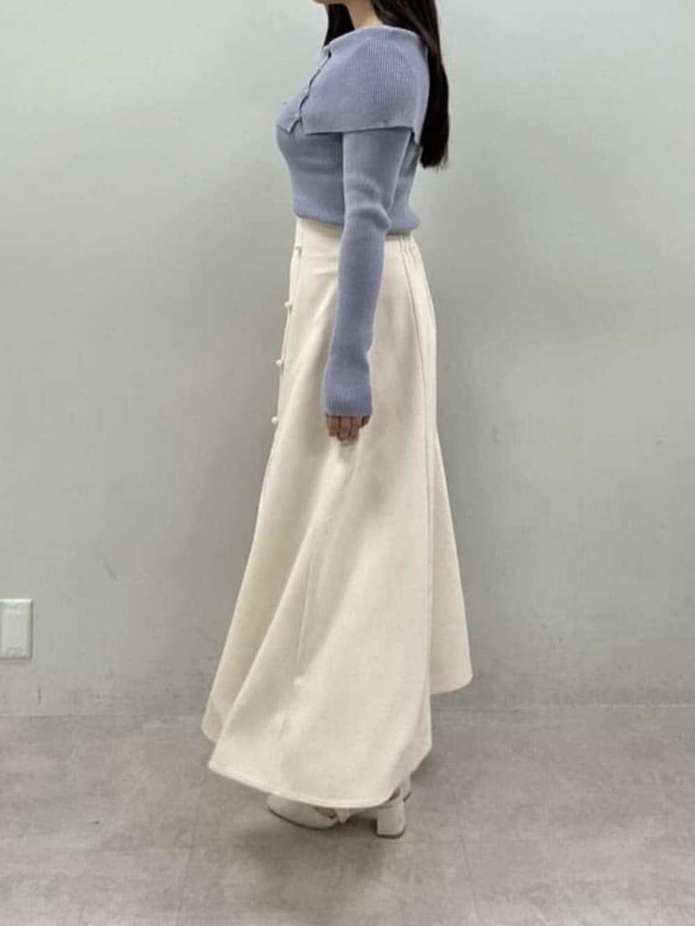 ホワイト系のサンダル、ブルー系のニット/セーター、ホワイト系のスカートを着用したレディースの冬コーディネートの2枚目の写真