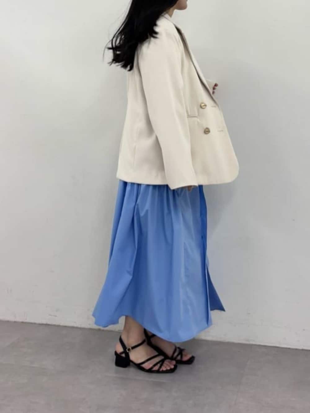 ホワイト系のテーラードジャケット、ブルー系のシャツワンピースを着用したレディースの春コーディネートの3枚目の写真