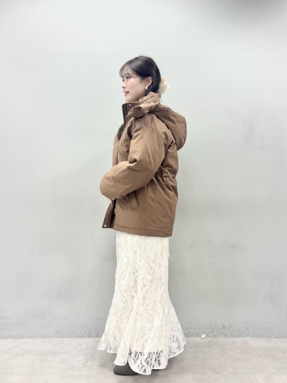 ホワイト系のニット/セーター、ブラウン系のダウンジャケット/コートを着用したレディースの秋コーディネートの5枚目の写真