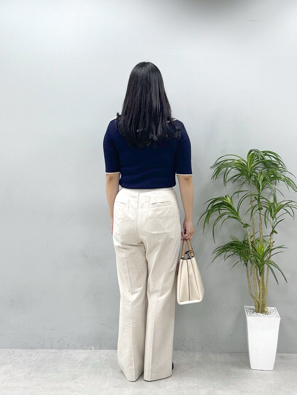 ホワイト系のショルダーバッグ、ベージュ系のその他パンツ、ブルー系のニット/セーターを着用したレディースの春コーディネートの3枚目の写真