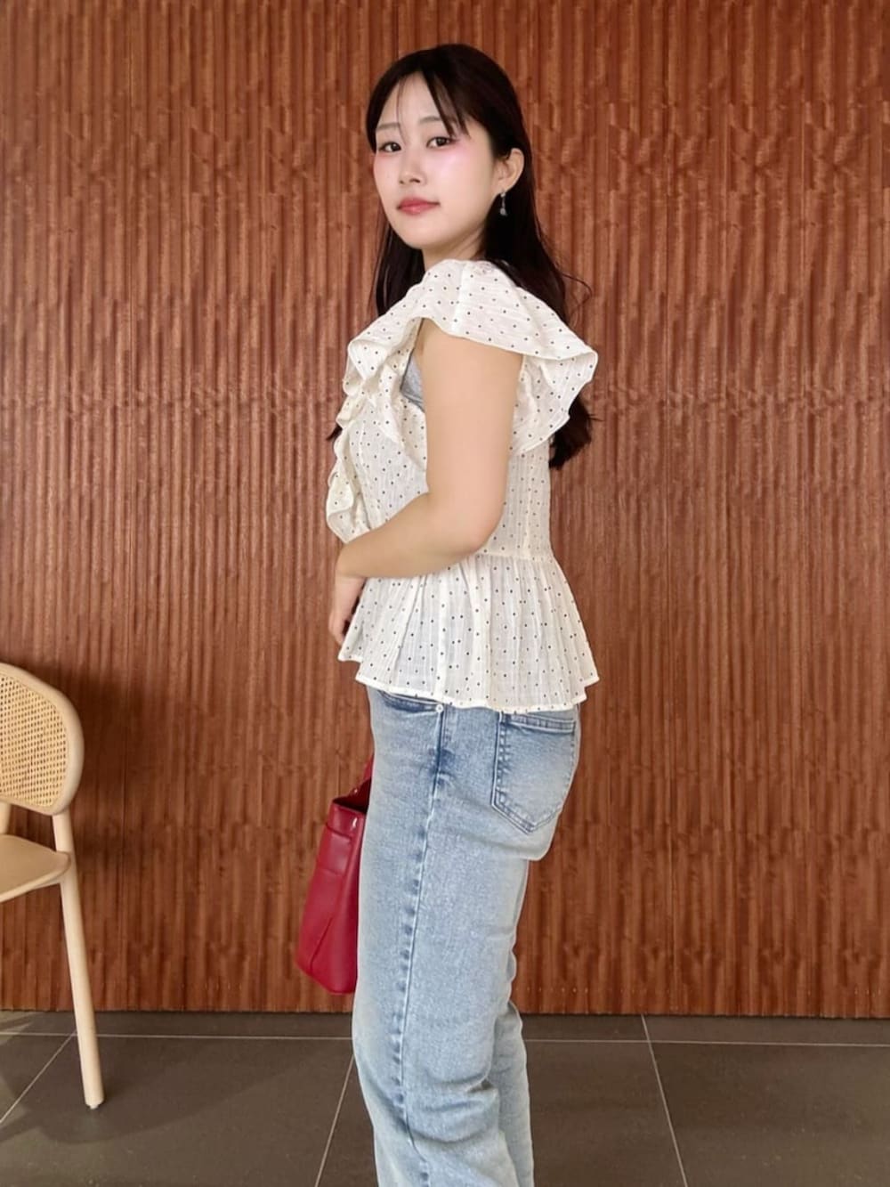 ブルー系のデニムパンツ、レッド系のショルダーバッグ、ホワイト系のシャツ/ブラウスを着用したレディースの春コーディネートの3枚目の写真