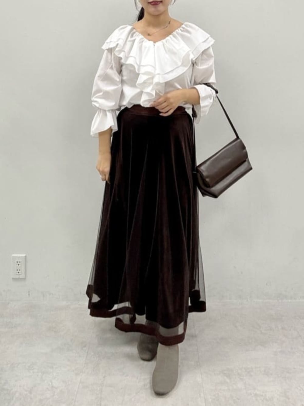 ブラウン系のスカート、グレー系のテーラードジャケットを着用したレディースの秋コーディネートの10枚目の写真