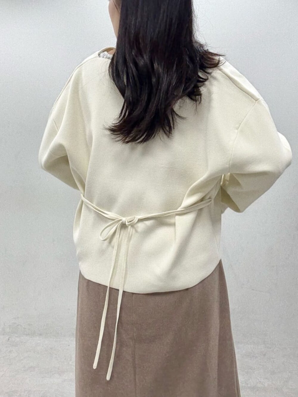 ブラウン系のスカート、グレー系のTシャツ/カットソー、ホワイト系のカーディガン/ボレロを着用したレディースの秋コーディネートの7枚目の写真