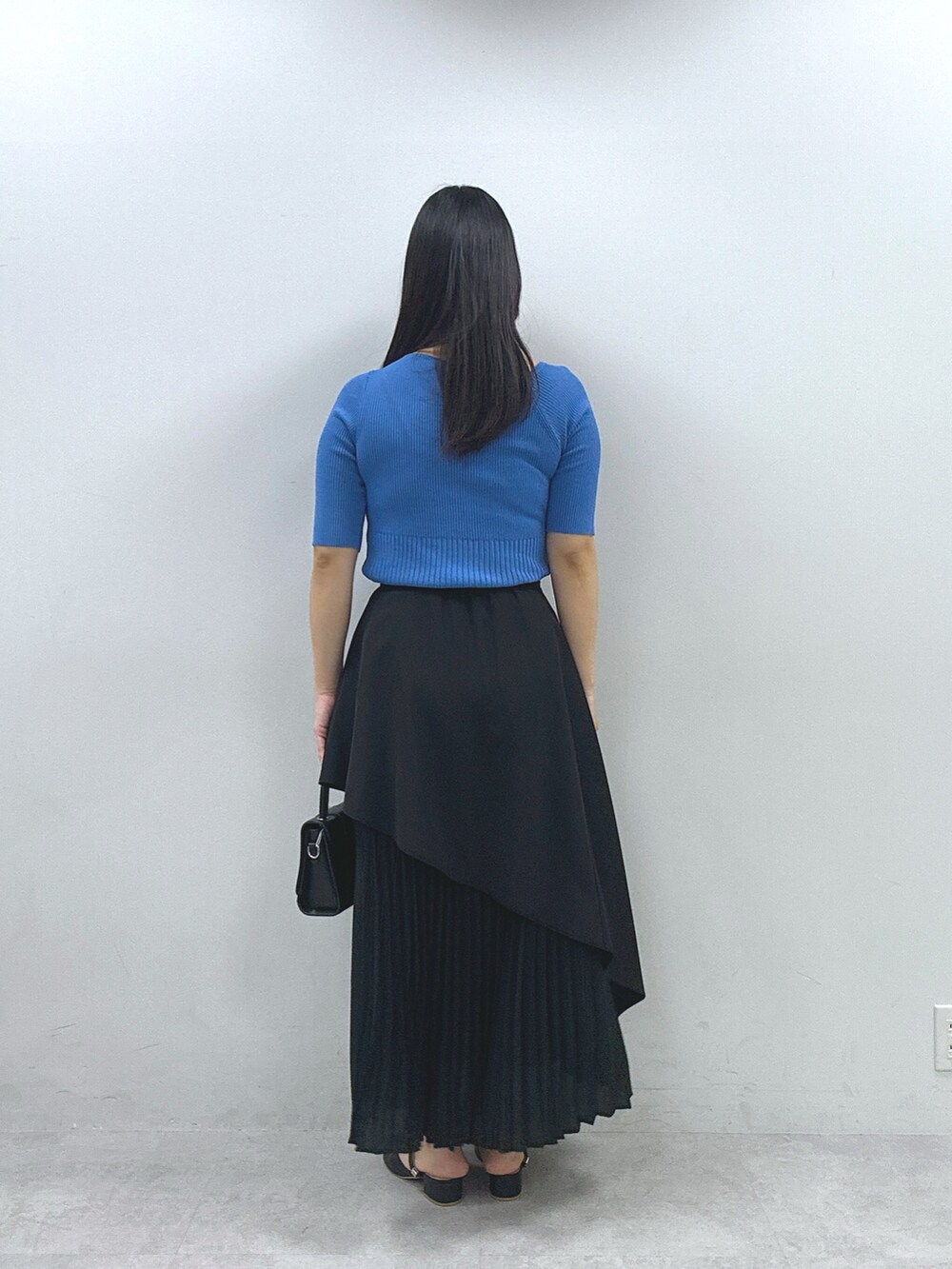 ブラック系のスカート、ブルー系のニット/セーターを着用したレディースの春コーディネートの3枚目の写真