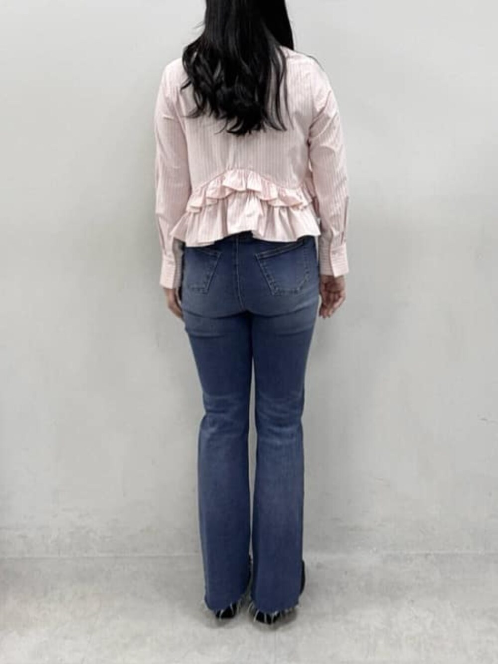 ブルー系のデニムパンツ、ブラック系のその他シューズ、ピンク系のシャツ/ブラウスを着用したレディースの冬コーディネートの3枚目の写真