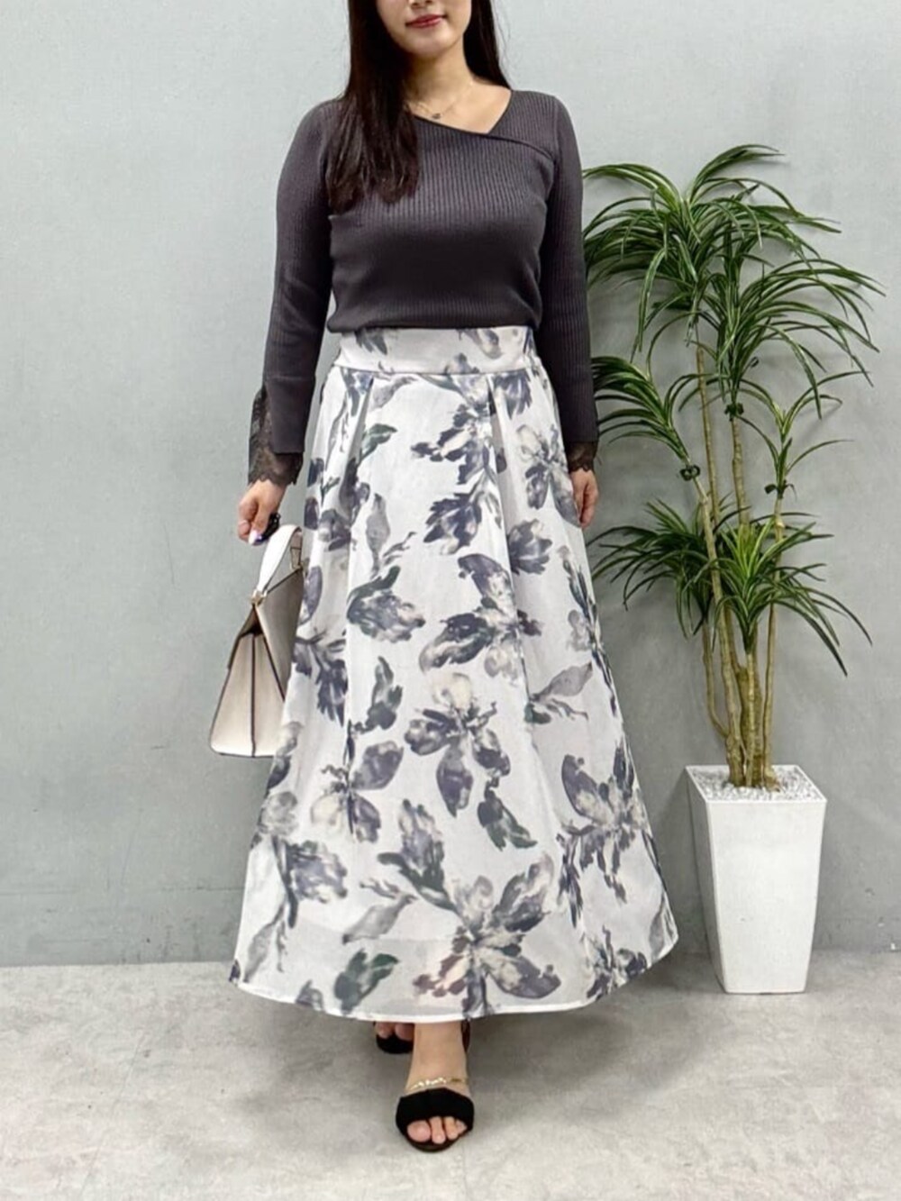 グレー系のニット/セーター、ホワイト系のスカートを着用したレディースの夏コーディネートの5枚目の写真