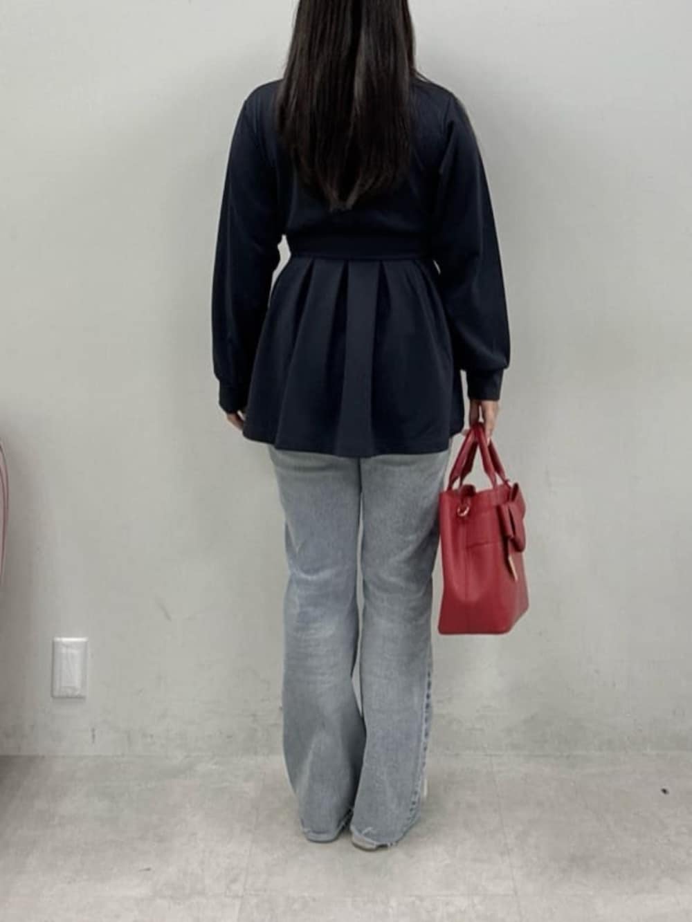 ブルー系のデニムパンツ、ブルー系のその他トップス、レッド系のショルダーバッグを着用したレディースの冬コーディネートの3枚目の写真