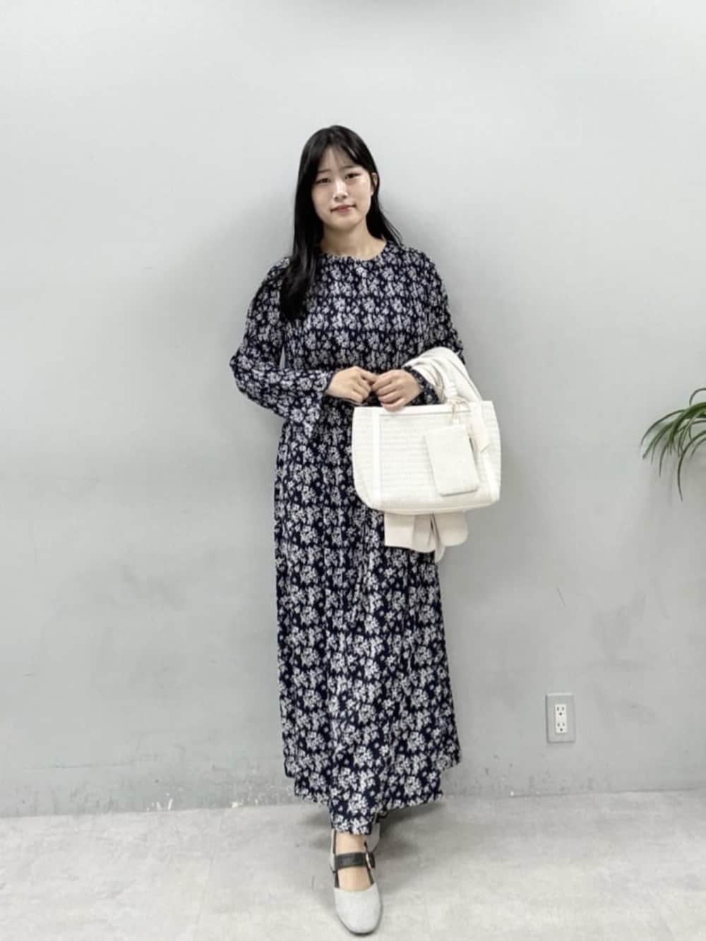 ホワイト系のテーラードジャケット、ホワイト系のハンドバッグ、グレー系のサンダルを着用したレディースの冬コーディネートの4枚目の写真