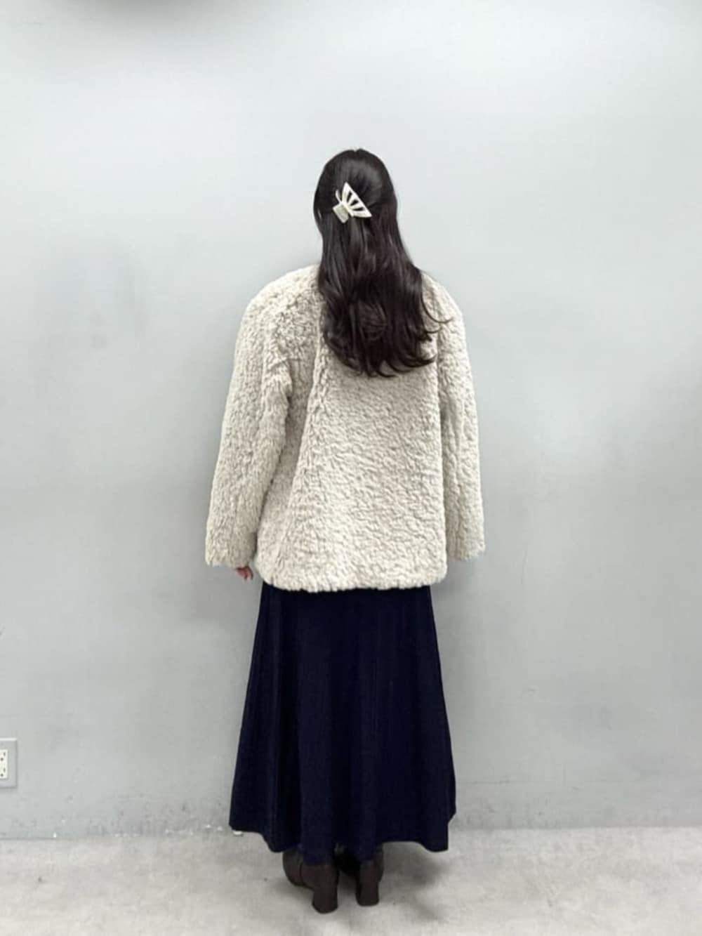 ブルー系のワンピース、ベージュ系のノーカラーコートを着用したレディースの秋コーディネートの3枚目の写真