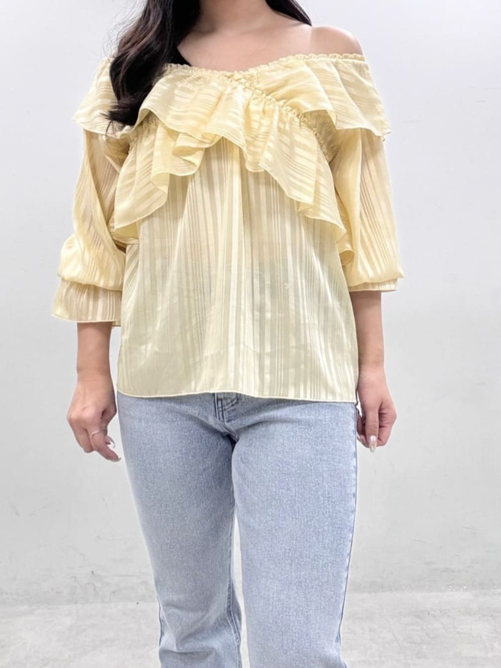 イエロー系のシャツ/ブラウス、ブルー系のデニムパンツを着用したレディースの冬コーディネートの5枚目の写真