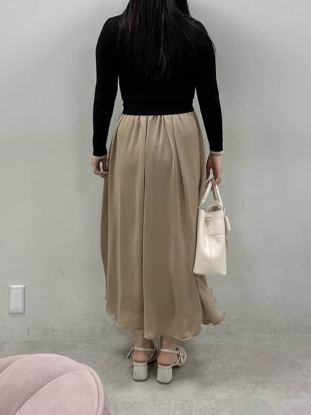 ホワイト系のショルダーバッグ、ホワイト系のサンダル、ブラック系のワンピースを着用したレディースの冬コーディネートの3枚目の写真