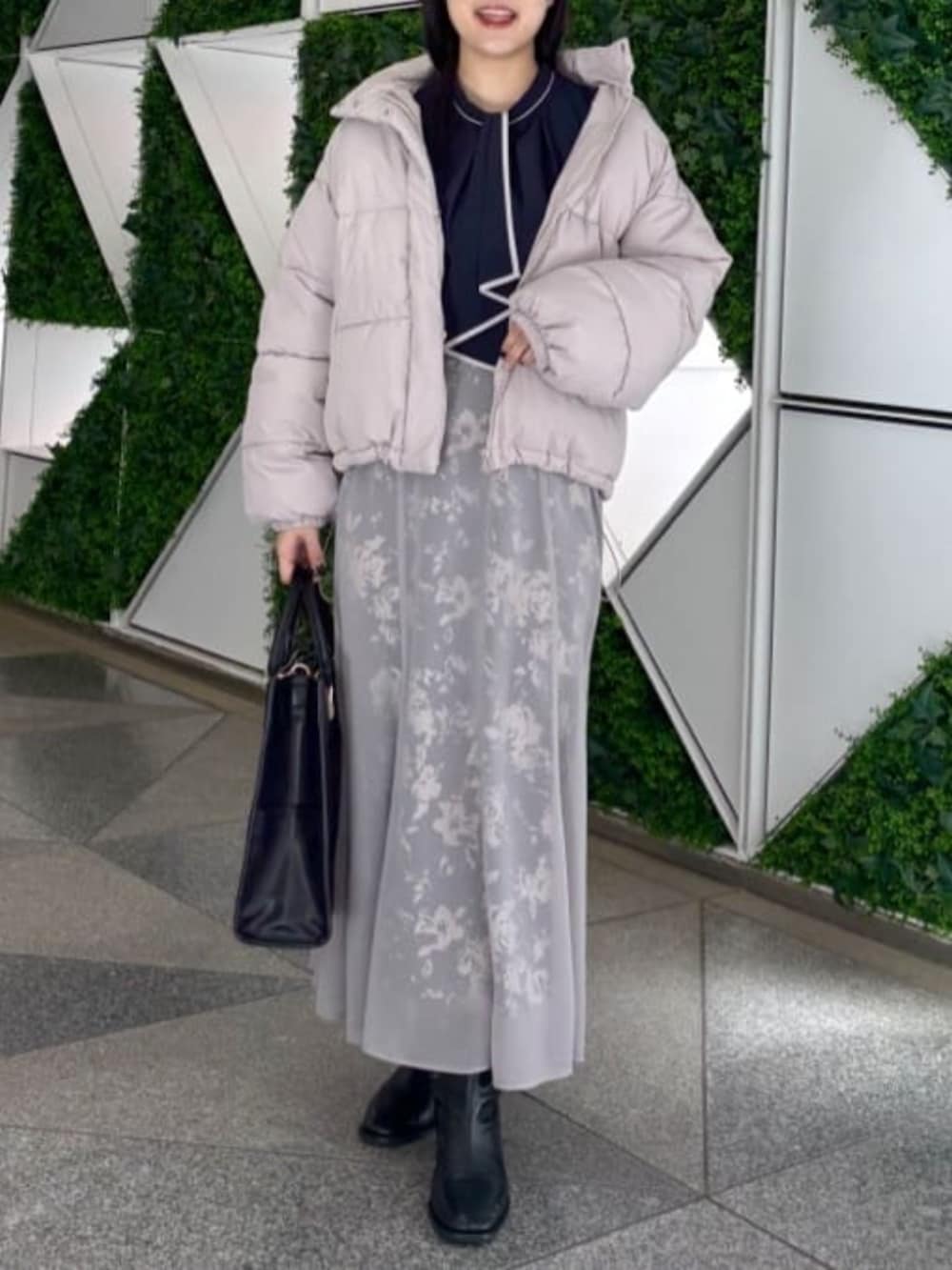 ブラック系のスカート、ベージュ系のダウンジャケット/コート、ブルー系のシャツ/ブラウスを着用したレディースの秋コーディネートの2枚目の写真