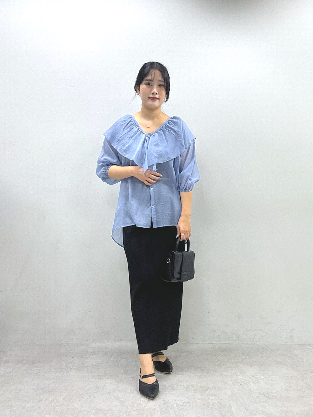 ブラック系のスカート、ブルー系のシャツ/ブラウスを着用したレディースの春コーディネートの3枚目の写真