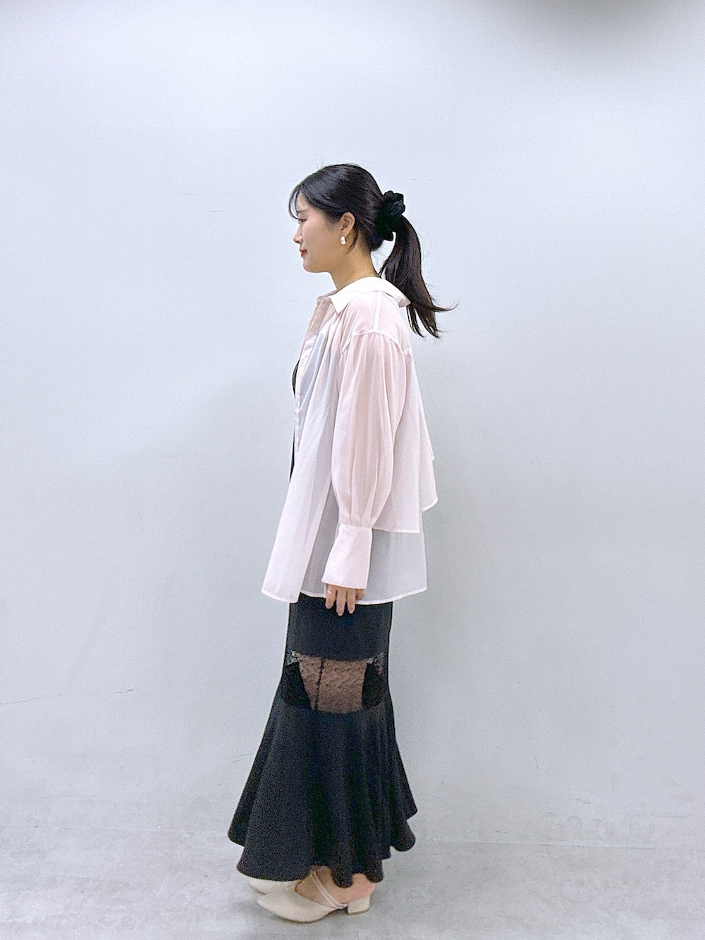 ピンク系のシャツ/ブラウス、ブラック系のワンピースを着用したレディースの春コーディネートの2枚目の写真