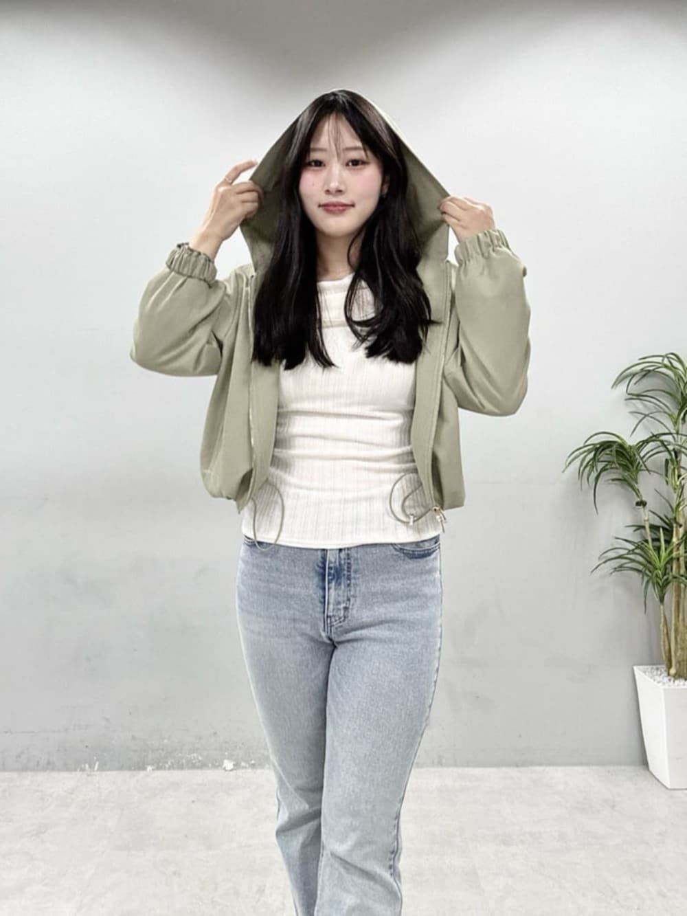 ブルー系のデニムパンツ、ホワイト系のニット/セーターを着用したレディースの春コーディネートの6枚目の写真