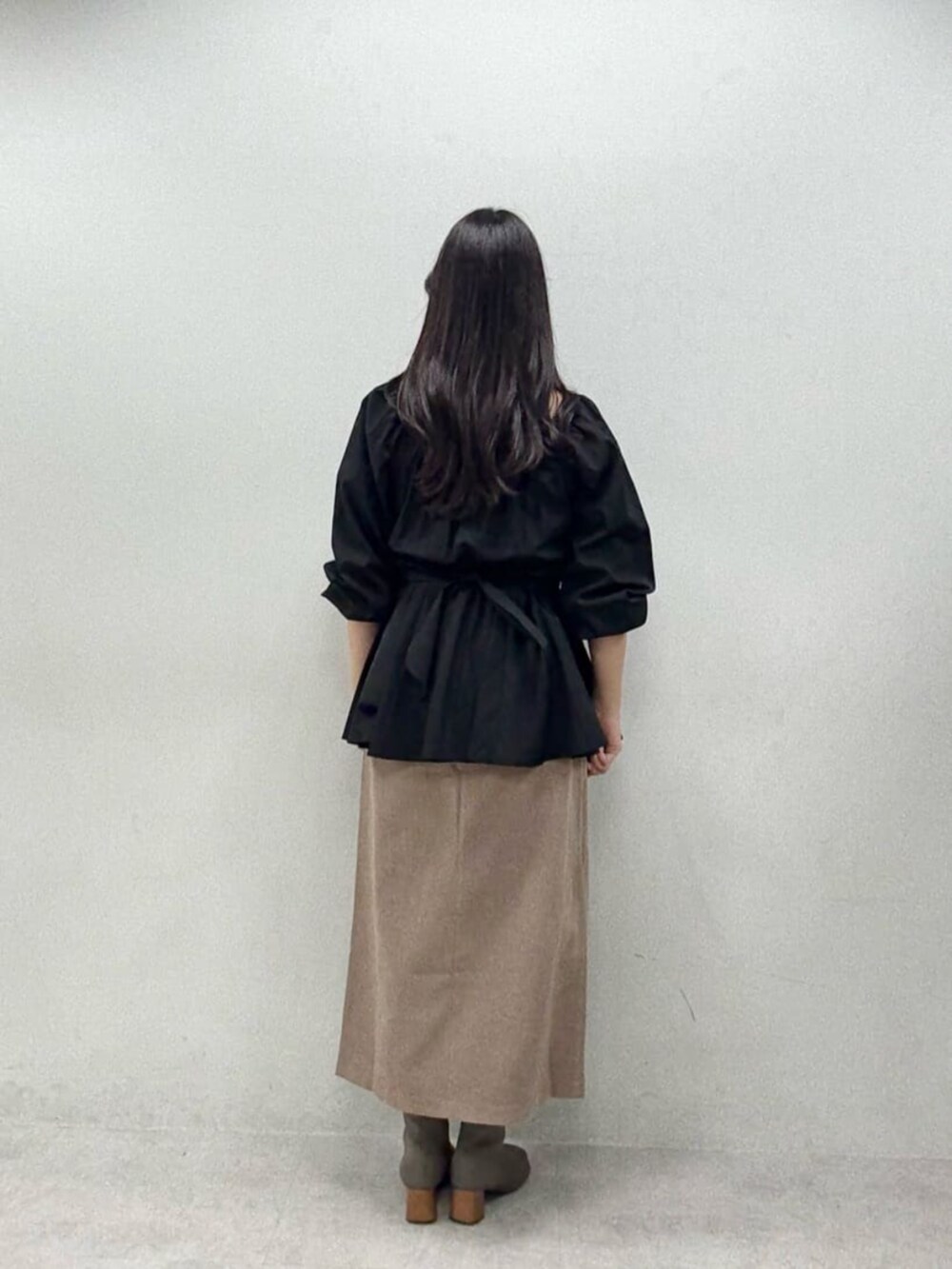 ブラウン系のスカート、ブラック系のシャツ/ブラウスを着用したレディースの秋コーディネートの2枚目の写真