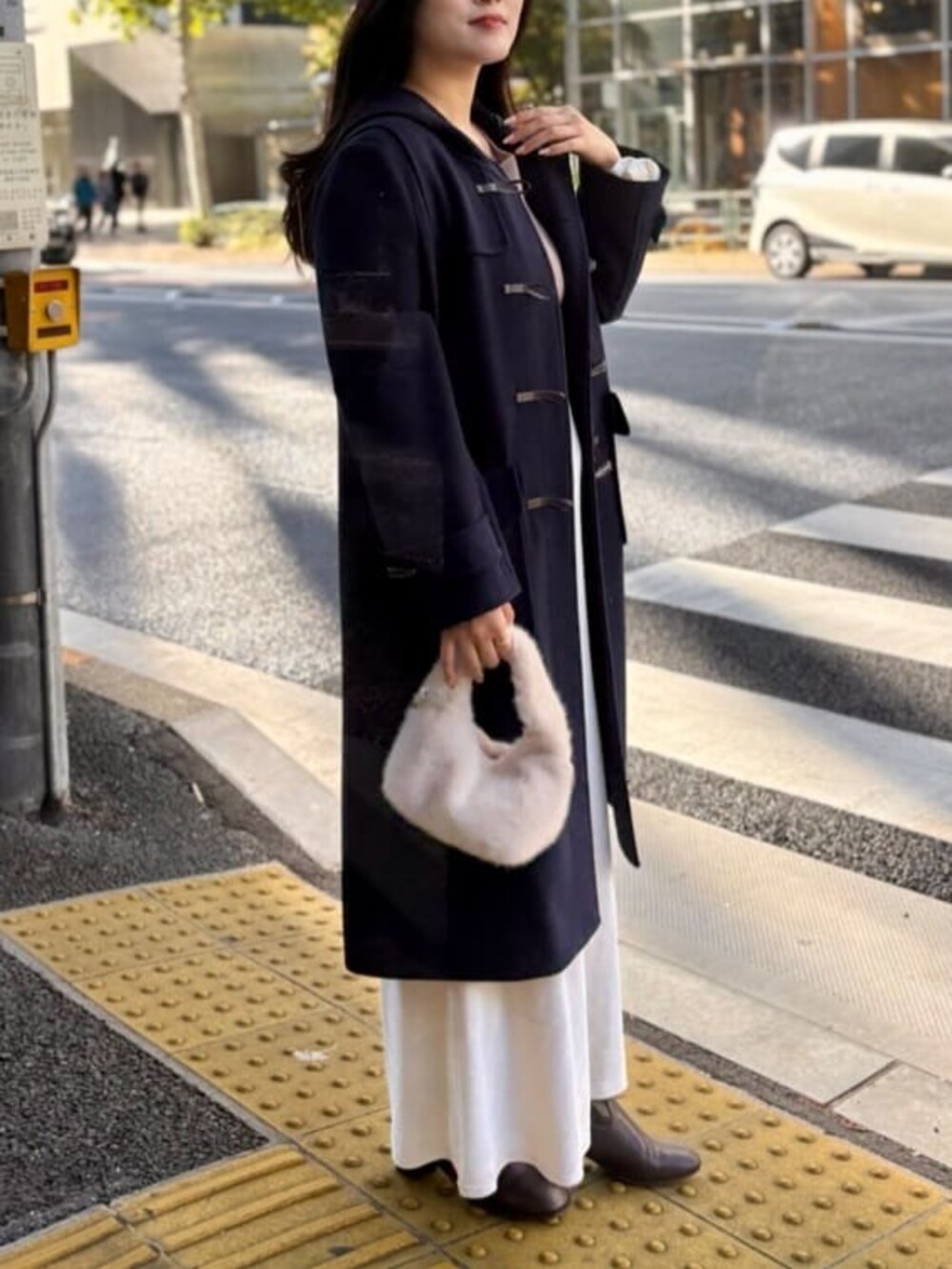 ホワイト系のスカート、ベージュ系のニット/セーターを着用したレディースの冬コーディネートの4枚目の写真