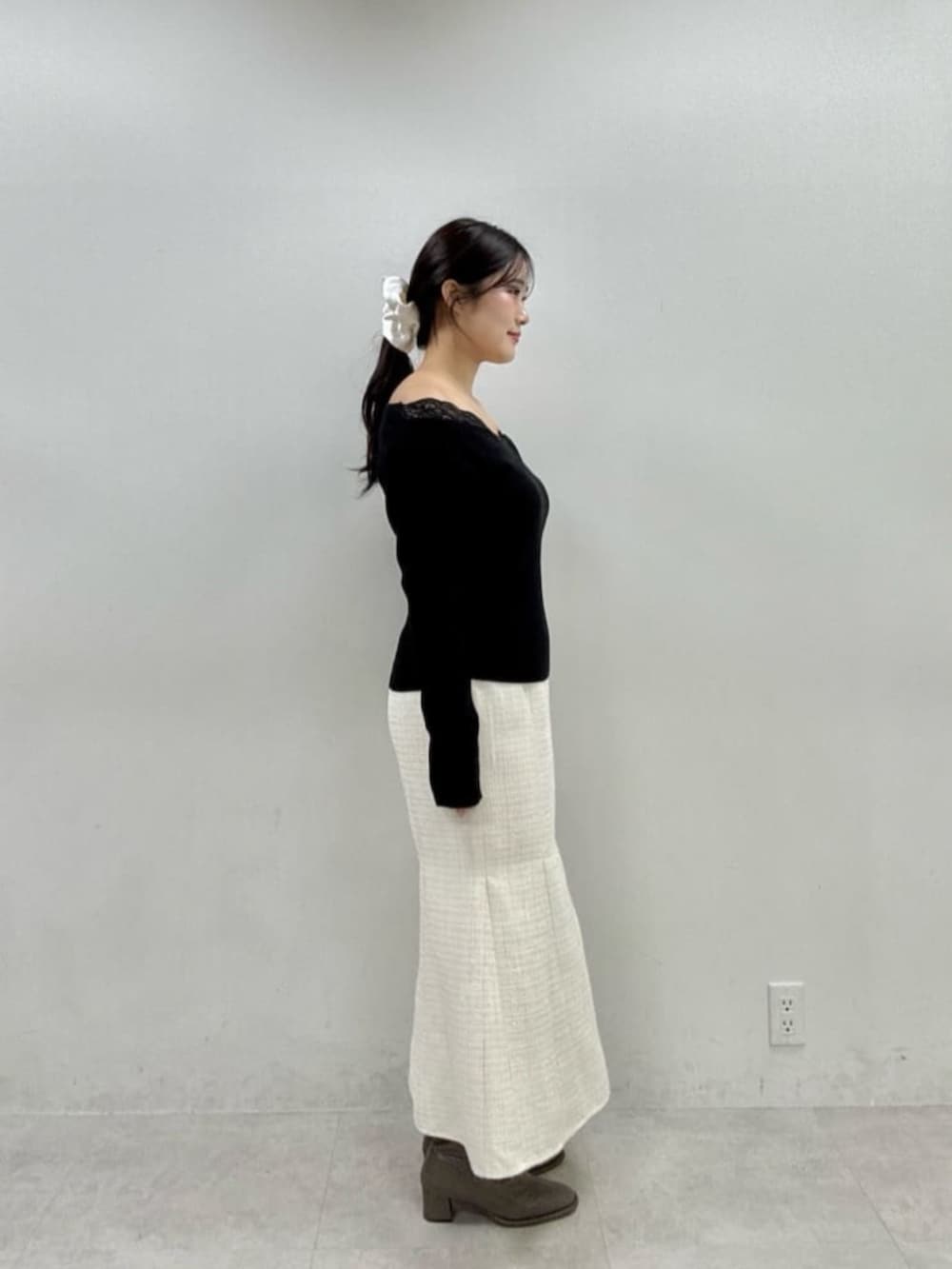 ホワイト系のスカート、ブラック系のニット/セーターを着用したレディースの秋コーディネートの2枚目の写真