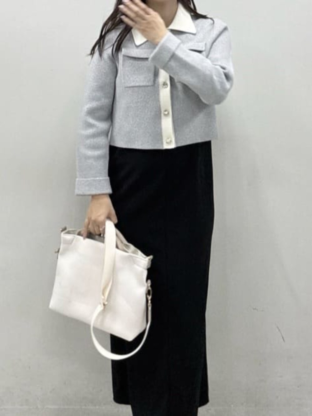 グレー系のカーディガン/ボレロ、ブラック系のワンピース、ホワイト系のトートバッグを着用したレディースの冬コーディネートの5枚目の写真