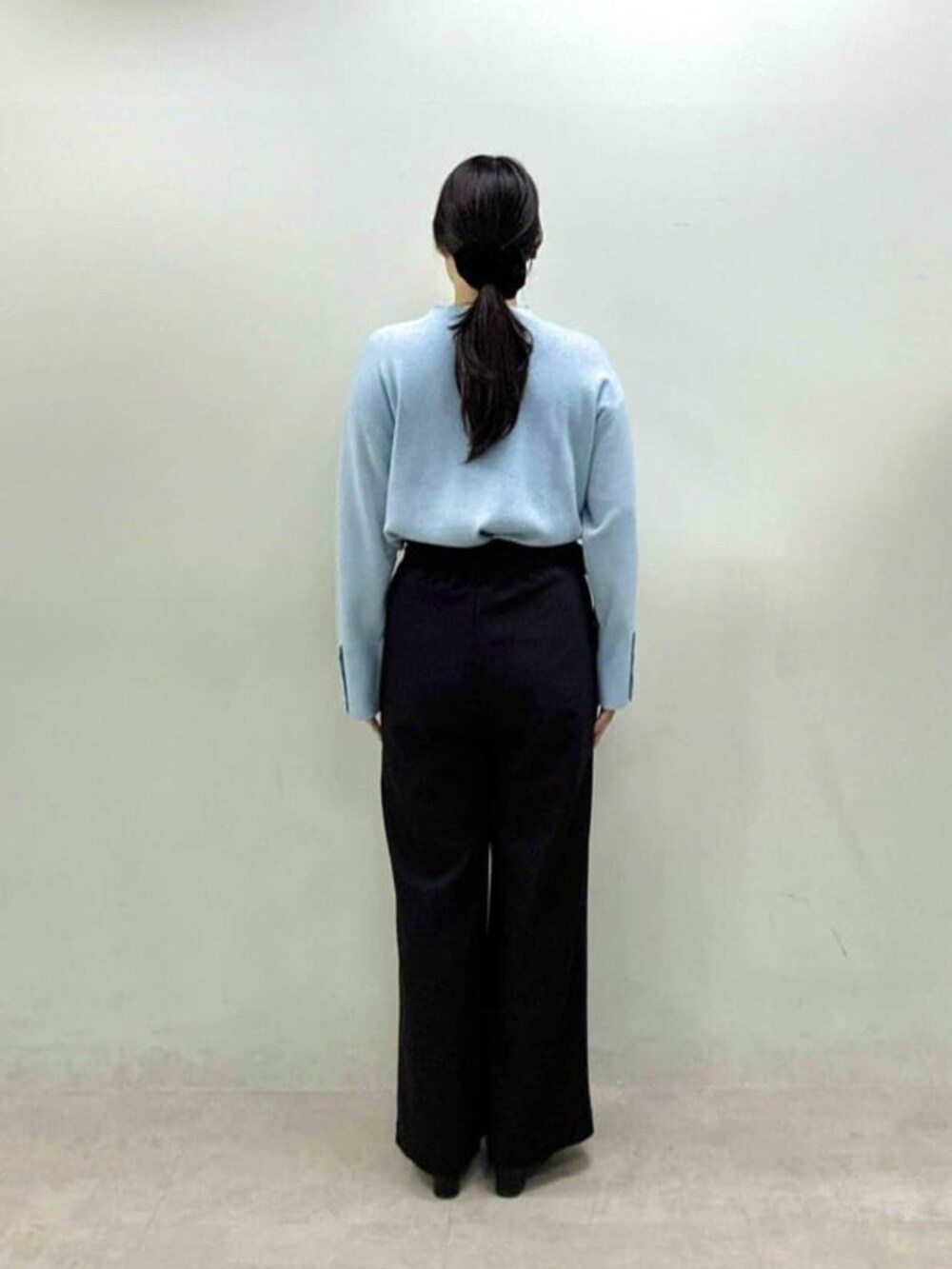 ブルー系のニット/セーター、ブラック系のその他パンツを着用したレディースの秋コーディネートの3枚目の写真