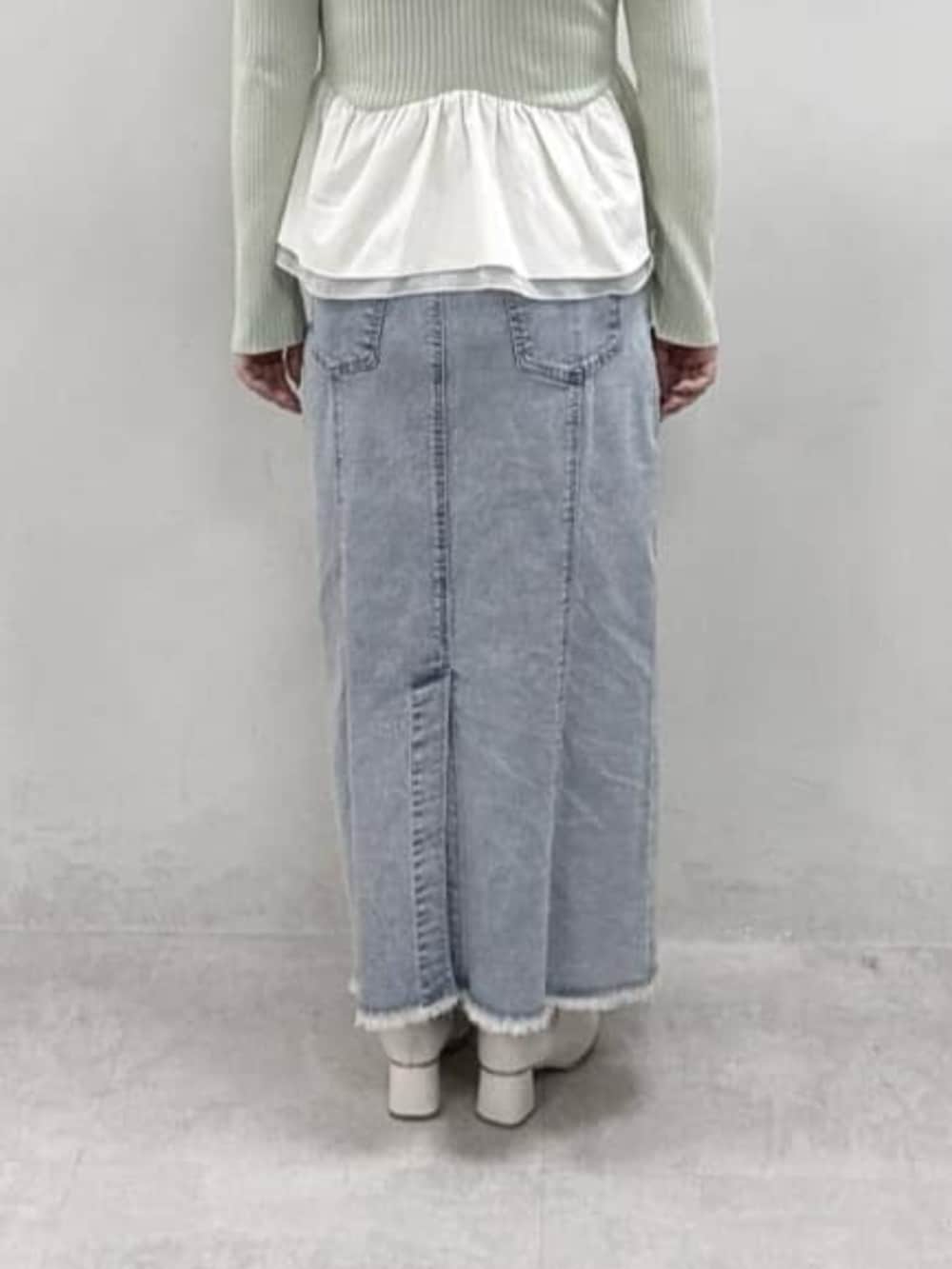 グリーン系のニット/セーター、ブルー系のデニムスカートを着用したレディースの冬コーディネートの3枚目の写真