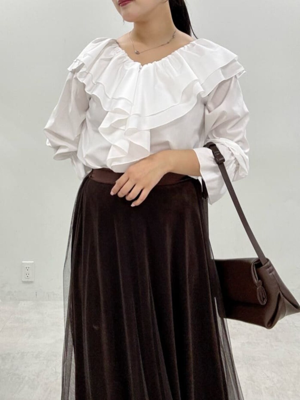 ブラウン系のスカート、グレー系のテーラードジャケットを着用したレディースの秋コーディネートの6枚目の写真