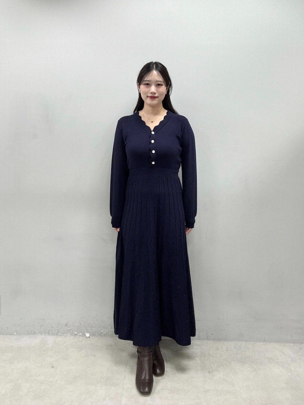 ブルー系のワンピース、ベージュ系のノーカラーコートを着用したレディースの秋コーディネートの4枚目の写真