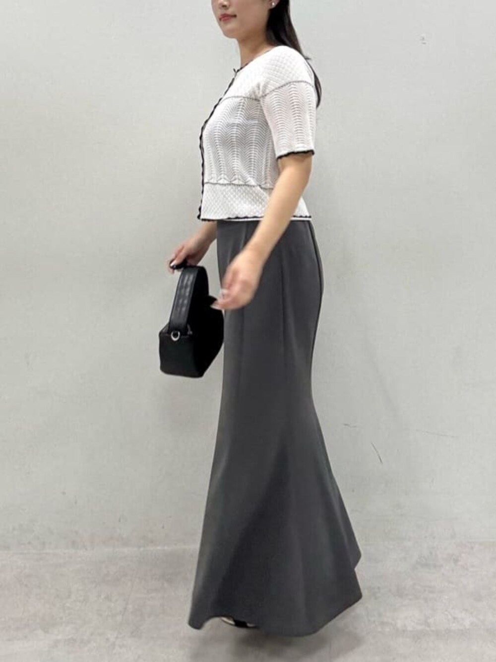 グレー系のスカート、ホワイト系のカーディガン/ボレロを着用したレディースの夏コーディネートの4枚目の写真