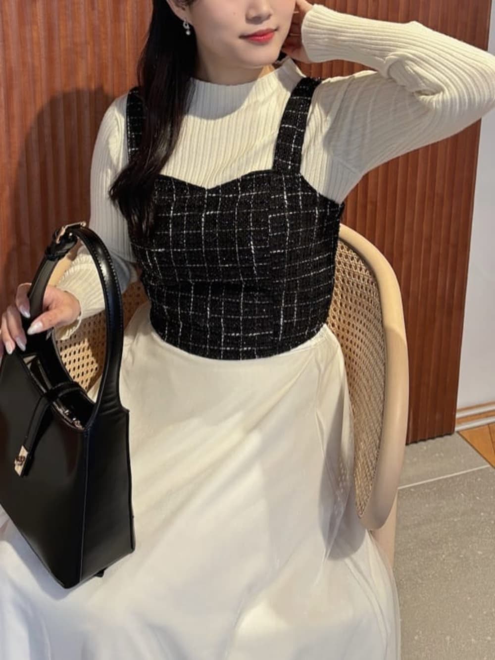 ホワイト系のスカート、ブラック系のシャツ/ブラウス、ホワイト系のニット/セーターを着用したレディースの秋コーディネートの4枚目の写真