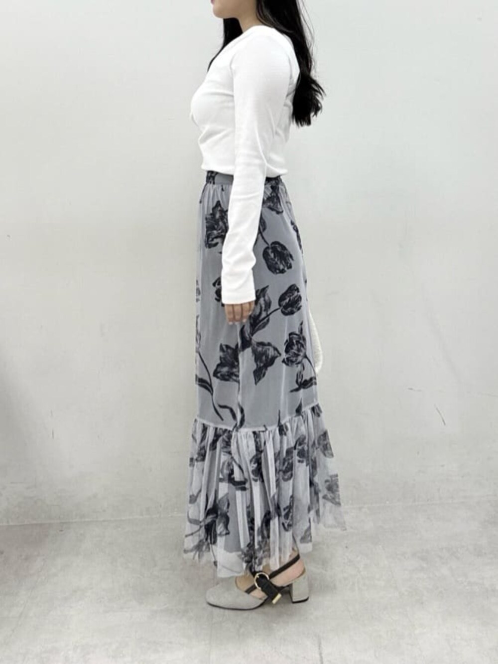 ホワイト系のハンドバッグ、グレー系のサンダル、ホワイト系のニット/セーターを着用したレディースの冬コーディネートの2枚目の写真