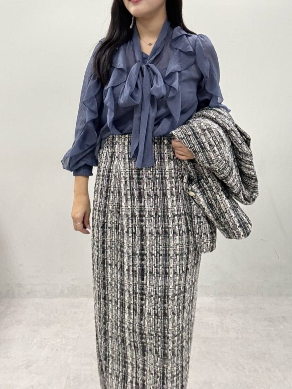 グレー系のスカート、グレー系のノーカラージャケット、ブルー系のシャツ/ブラウスを着用したレディースの秋コーディネートの5枚目の写真