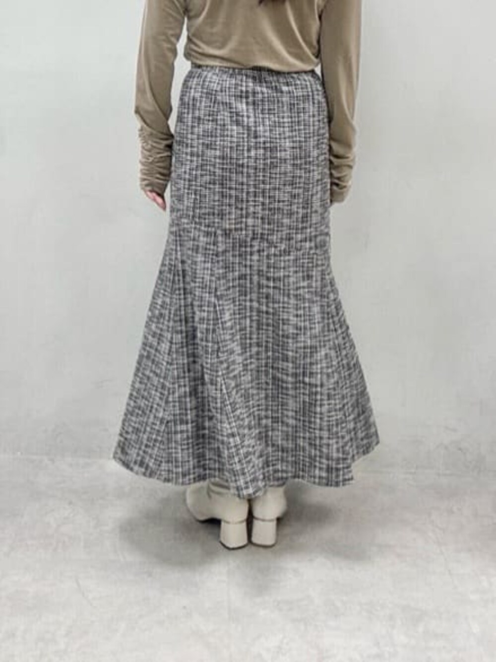 ベージュ系のTシャツ/カットソー、ブラック系のスカートを着用したレディースの冬コーディネートの3枚目の写真
